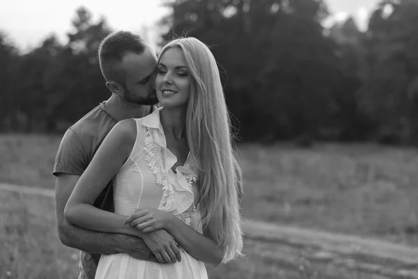 Preto e branco foto motociclista casal em uma motocicleta no campo . — Fotografia de Stock