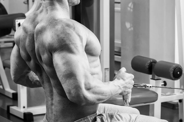 Homem musculoso forte fazendo exercícios no ginásio . — Fotografia de Stock