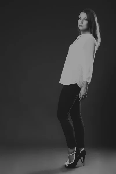 Stilvoll gekleidete junge Geschäftsfrau. das Bild einer schönen jungen Geschäftsfrau. Mädchen in schwarzer Hose und weißem Hemd vor dunklem Hintergrund. Foto für Mode- und Sozialmagazine, Webseiten. — Stockfoto