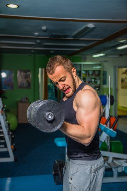 Adam jimnastik salonu. Egzersiz halter kılıyor. Spor, güç, halter, gerginlik, egzersiz - sağlıklı bir yaşam tarzı kavramı. Fitness ve spor hakkında makale.