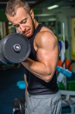 Adam jimnastik salonu. Egzersiz halter kılıyor. Spor, güç, halter, gerginlik, egzersiz - sağlıklı bir yaşam tarzı kavramı. Fitness ve spor hakkında makale.