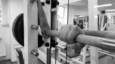 Bir adam bir egzersiz halter ile gerçekleştirir. Spor salonunda genç halterci. Atletik, sağlıklı, kaslı adam. Sağlıklı yaşam konsepti. Halter.