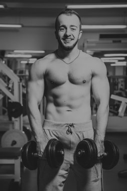 Adam jimnastik salonu. Egzersiz halter kılıyor. Spor, güç, halter, gerginlik, egzersiz - sağlıklı bir yaşam tarzı kavramı. Fitness ve spor hakkında makale.