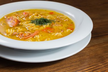 Çorba, sebze ve otlar beyaz plaka.