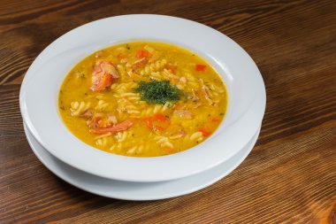 Çorba, sebze ve otlar beyaz plaka.