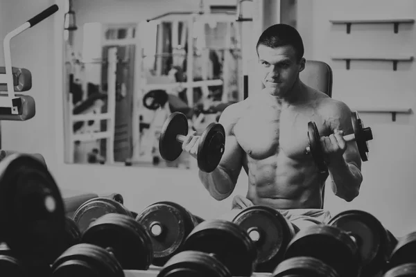 Muskulöser Typ, der mit freien Gewichten arbeitet. — Stockfoto