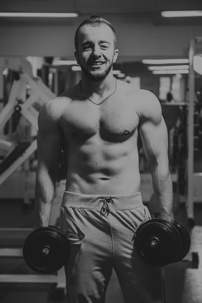 Az ember az edzőteremben. Az ember teszi a gyakorlatok súlyzó. Sport, erő, súlyzók, feszültség, mozgás - az egészséges életmód fogalma. Fitness és sport cikk. — Stock Fotó