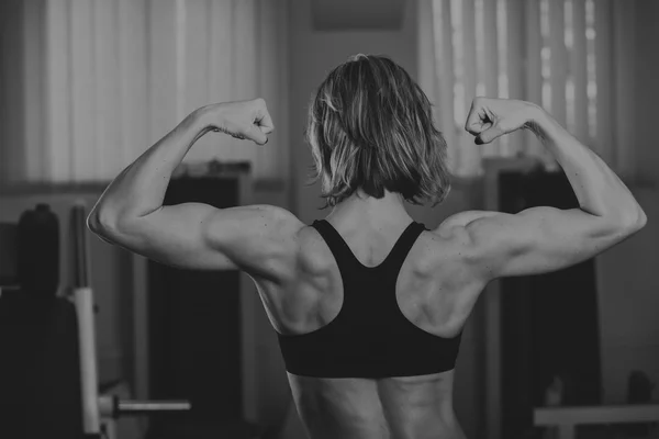 Sportliche Frau in gym.beautiful muskulös fit Frau beim Training Gebäude muscles.nice sexy Frau beim Training in der Turnhalle. — Stockfoto