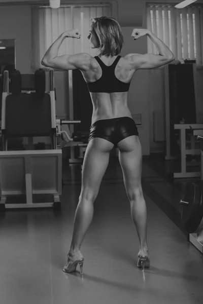 Mujer deportiva en gimnasio.Hermosa mujer en forma muscular haciendo ejercicio musculares.Nice mujer sexy haciendo ejercicio en el gimnasio . — Foto de Stock