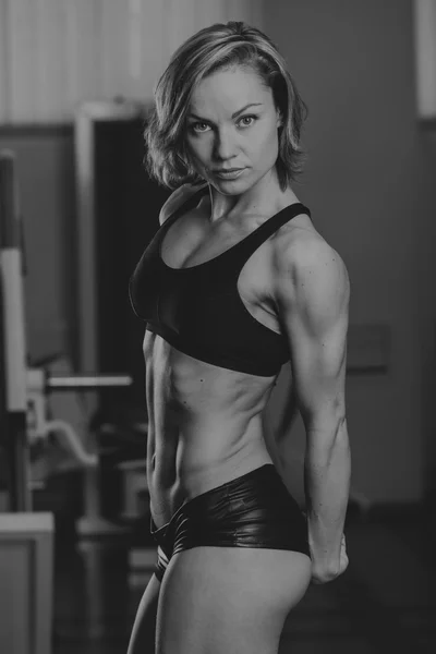 在健身房的运动型女人。美丽肌适合行使建设肌肉的女人。漂亮性感的女人做在健身房锻炼. — 图库照片