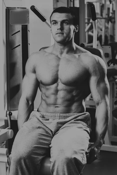 Fuerte hombre muscular haciendo ejercicios en el gimnasio . — Foto de Stock