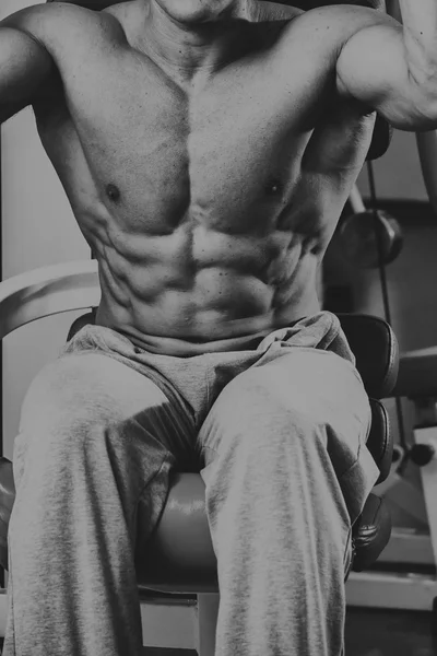 Silne muskularny mężczyzna robi ćwiczenia w siłowni. — Zdjęcie stockowe
