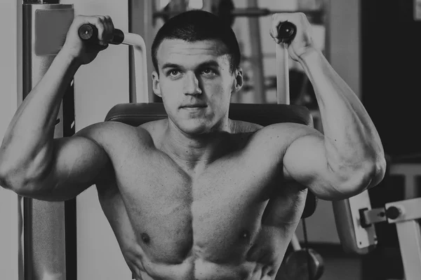 Homme musclé fort faisant des exercices dans la salle de gym . — Photo