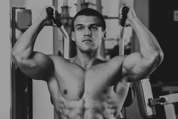 Starker muskulöser Mann bei Übungen im Fitnessstudio. — Stockfoto