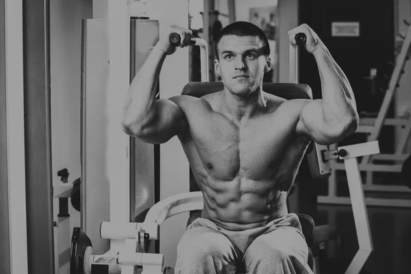 Homme musclé fort faisant des exercices dans la salle de gym . — Photo