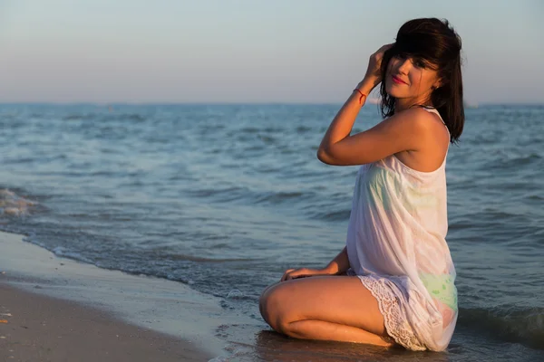 La jeune belle fille en robe blanche sur la plage. Photo belle fille sur la plage. Fille posant de manière séduisante. Photo pour magazines de voyage et sociaux, affiches et sites web . — Photo