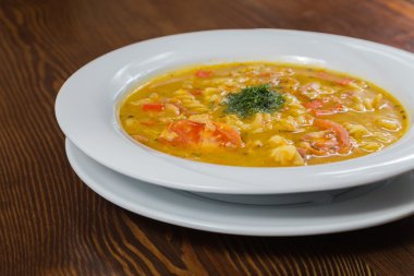 Çorba, sebze ve otlar beyaz plaka.