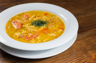 Çorba, sebze ve otlar beyaz plaka.