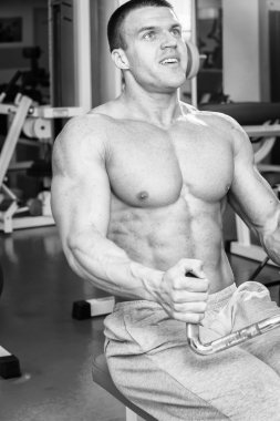 Güçlü kas adam jimnastik egzersizleri yapıyor. Güzel vücut üzerinde bir siyah beyaz fotoğraf. Sağlıklı yaşam tarzı.