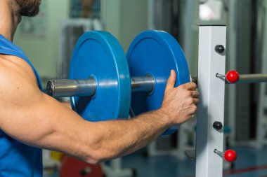 Vücut geliştirme dumbbells ile. Husky büyük bir dumbbell elinde tutar. Spor, vücut geliştirme, sağlıklı yaşam tarzı.