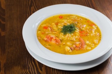 Çorba, sebze ve otlar beyaz plaka.