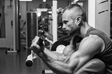 Atlet pazı simülatör spor salonunda tezgah. El kas eğitim simülatör. Gergin kasları el yük altında. Fotoğraflar spor dergileri, afiş ve Web siteleri için.