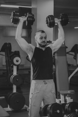 Adam jimnastik salonu. Egzersiz halter kılıyor. Spor, güç, halter, gerginlik, egzersiz - sağlıklı bir yaşam tarzı kavramı. Fitness ve spor hakkında makale.