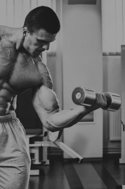 Vücut geliştirmeci yapar egzersiz jimnastik salonu dumbbells ile.