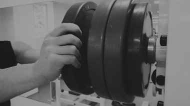 Bir adam bir egzersiz halter ile gerçekleştirir. Spor salonunda genç halterci. Atletik, sağlıklı, kaslı adam. Sağlıklı yaşam konsepti. Halter.