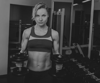 Spor sarışın. Güzel güçlü kız. Bodyfitness, kadın fitness. Kadın spor yapıyor. Güzellik, sağlık ve spor. Vücut geliştirmeci genç yetişkin seksi kız