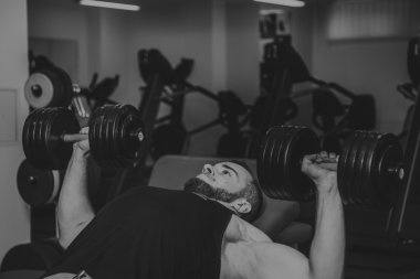 Adam jimnastik salonu. Egzersiz halter kılıyor. Spor, güç, halter, gerginlik, egzersiz - sağlıklı bir yaşam tarzı kavramı. Fitness ve spor hakkında makale.