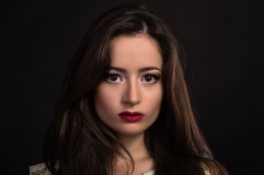 Karanlık bir arka plan üzerinde güzel genç esmer. Seksi seksi esmer. Lüks kadın şık makyaj ile.