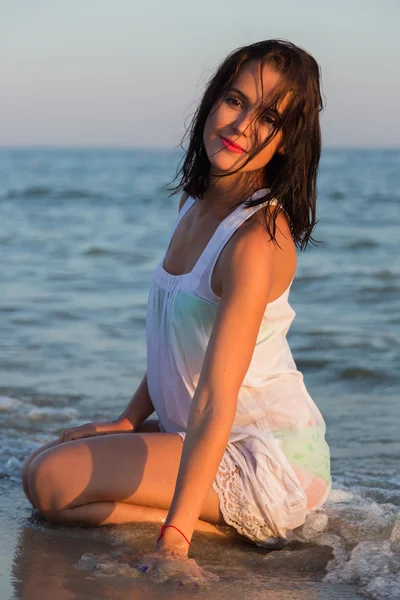 La jeune belle fille en robe blanche sur la plage. Photo belle fille sur la plage. Fille posant de manière séduisante. Photo pour magazines de voyage et sociaux, affiches et sites web . — Photo