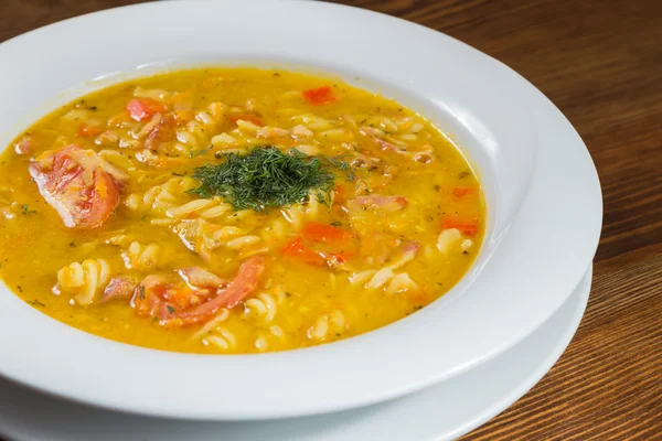 Çorba, sebze ve otlar beyaz plaka.