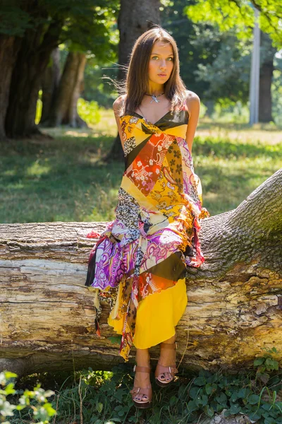 Ein junges und attraktives Mädchen im schönen Sommerkleid inmitten sonniger Wiesen. — Stockfoto