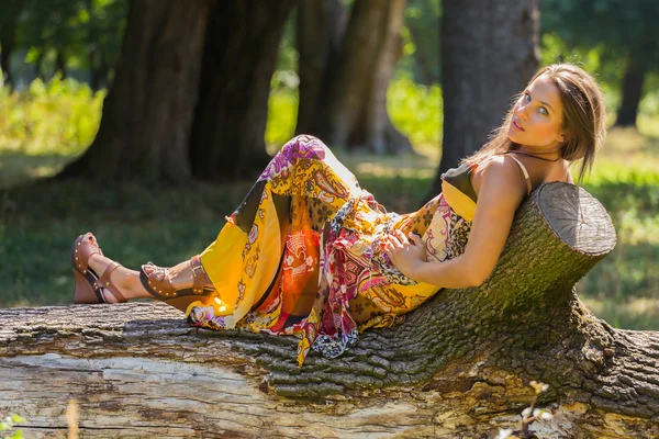 一个年轻、 有吸引力的女孩，在美丽的夏天穿衣服中间的阳光明媚的草地. — 图库照片