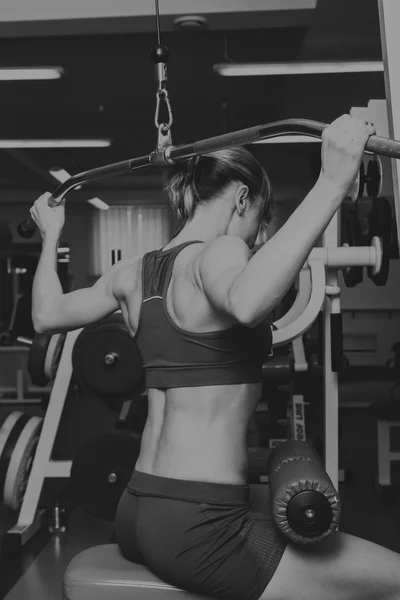 A menina bombeia os principais grupos musculares no ginásio. Treino de força. Aptidão feminina. Menina forte . — Fotografia de Stock