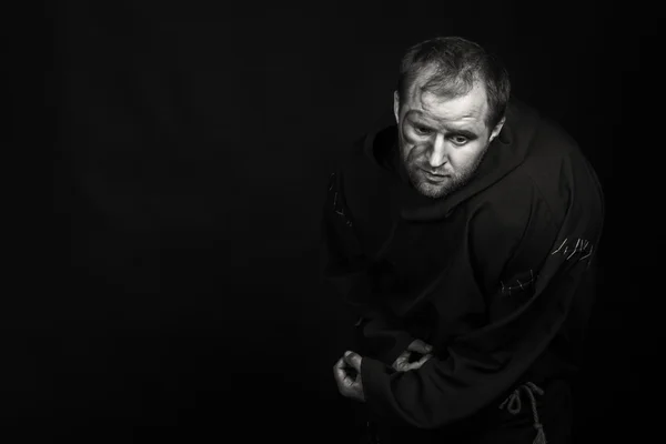 Beautiful and fascinating game theater actor on camera. Black and white photo of the actor in the guise of a beggar on a dark background. Beautifully decorated stage image and professional makeup.