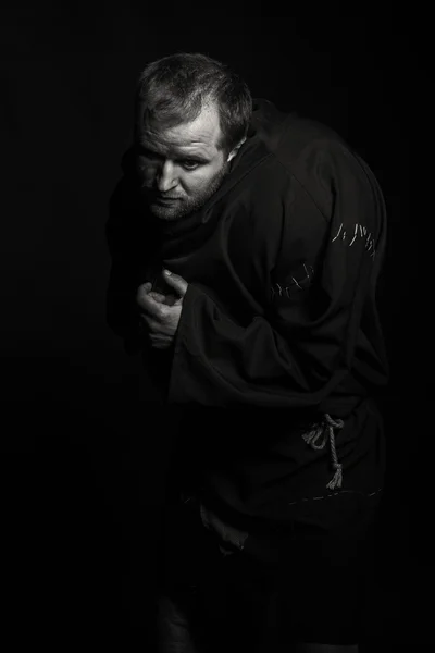 Magnifique et fascinant acteur de théâtre de jeu à la caméra. Photo en noir et blanc de l'acteur déguisé en mendiant sur un fond sombre. Image de scène magnifiquement décorée et maquillage professionnel . — Photo