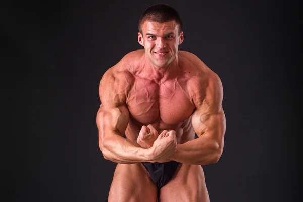 Bodybuilder posieren in verschiedenen Posen und demonstrieren ihre Muskeln. — Stockfoto