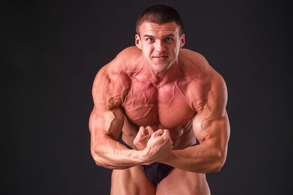 Bodybuilder posing in different poses demonstrating their muscles. — Stock Photo, Image