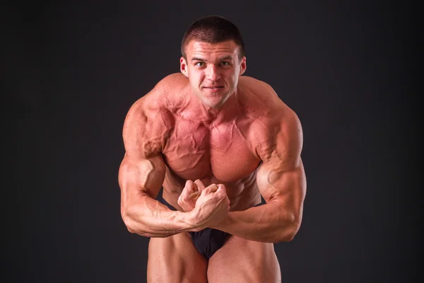 Bodybuilder posieren in verschiedenen Posen und demonstrieren ihre Muskeln. — Stockfoto
