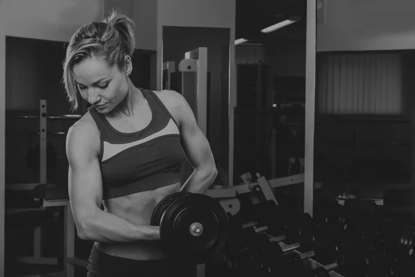 Sport blonde. Vacker stark tjej. Bodyfitness, kvinnors lämplighet. Kvinnan gör övningar på gymmet. Skönhet, hälsa och sport. Bodybuilder unga vuxna sexig tjej — Stockfoto