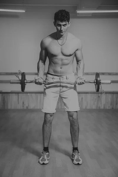 ダンベル運動のプロセス。男は、ジムで行っています。ジムでトレーニング。健康的なライフ スタイル。創造的な写真. — ストック写真