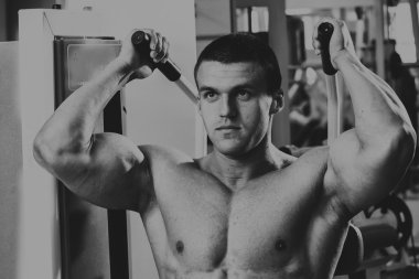 Güçlü kas adam jimnastik egzersizleri yapıyor. Güzel vücut üzerinde bir siyah beyaz fotoğraf. Sağlıklı yaşam tarzı.