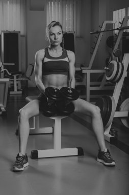 Spor sarışın. Güzel güçlü kız. Bodyfitness, kadın fitness. Kadın spor yapıyor. Güzellik, sağlık ve spor. Vücut geliştirmeci genç yetişkin seksi kız
