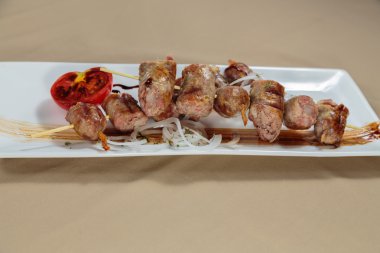 Beyaz bir tabakta sebze ve sos ile lezzetli sosis.