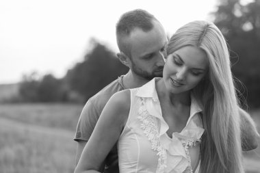 Siyah ve beyaz fotoğraf motorcu çift bir motosiklet alanında.