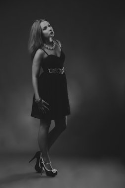 Karanlık bir arka plan üzerinde bir şık elbiseli seksi esmer