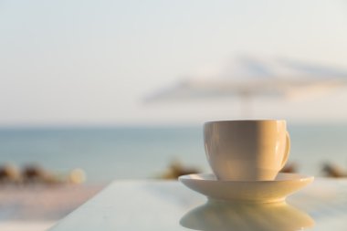 Sahilde bir kafede lezzetli kahve bir fincan. Lezzetli bir içecek. Deniz Manzaralı sakin ol. Fotoğraf dergi, arka planlar, posterler ve Web siteleri için.